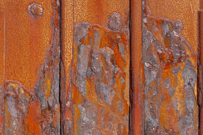 Rost 12 Rostige und verwitterte Holzoberfläche mit orangefarbenen und grauen Flecken.