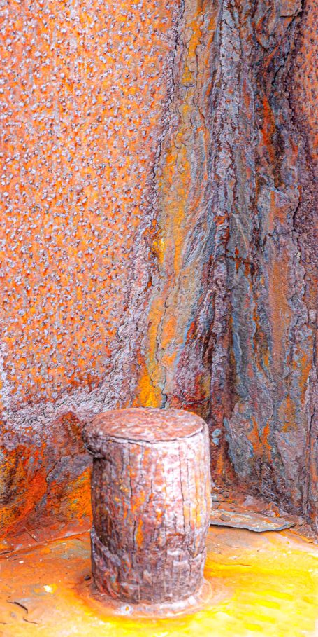 Rost 08 Rostige Metalloberfläche mit einem kleinen, runden Pfosten in der Ecke.