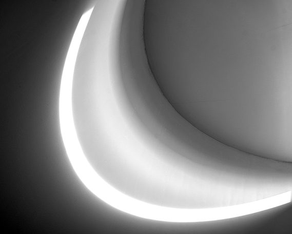 Blick nach oben 2 Weiße Lichtkurve in einem abgedunkelten Raum, sanft gebogen.